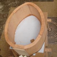 Cuna con forma oval en madera maciza de cerezo.